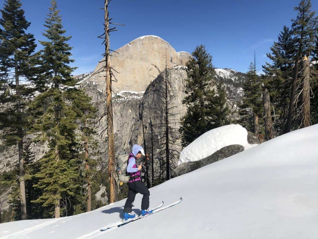 skier in front of Half Dome and Liberty Cap