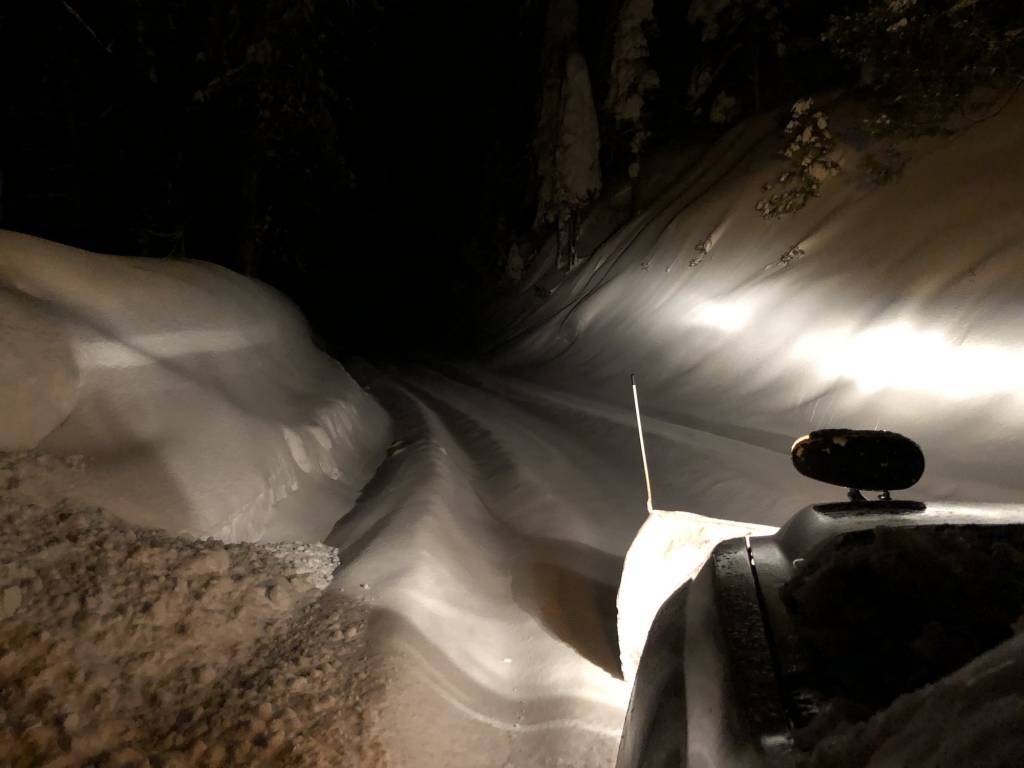 Snowy road at night from snowplow